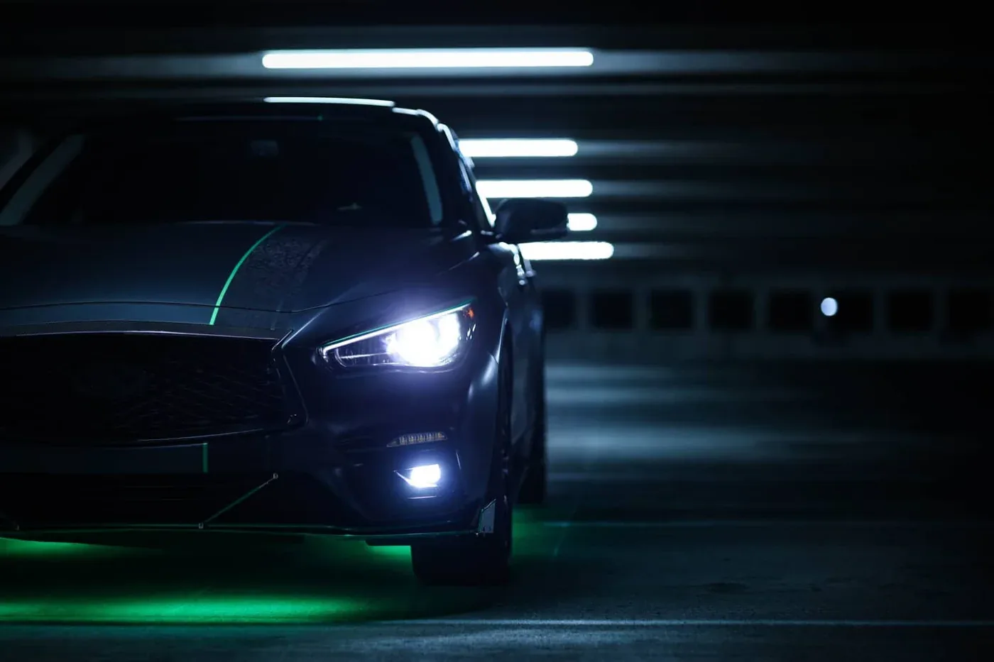 Infiniti Q50 with a green accent kit in the Evolution Wraps shop